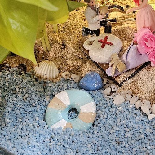 Detail of the shells and sand along the front edge of the piece.